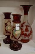 A pair of painted glass vases and a ruby glass vase.