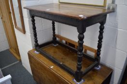 An oak occasional table with turned supports.