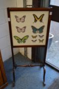A mahogany framed fire screen embroidered with butterfly panel.
