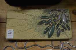 Decorative clutch bag mounted with hard stones.