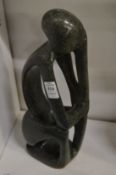 Contemporary carved stone sculpture of a seated figure.