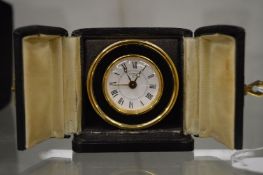 A Looping travelling clock with leather case.