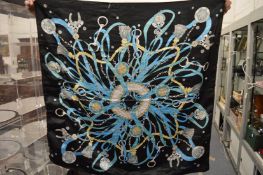 A Hermes Paris silk scarf, black ground, decorated with horse bits, ropes and tassels.