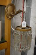 A pair of brass and cut glass wall lights.