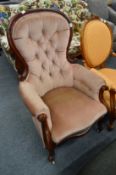 A Victorian mahogany framed button upholstered armchair.