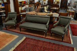 A Victorian ebonised and parcel gilded three piece suite comprising, settee and pair of armchairs