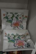 A pair of floral decorated ashtrays.