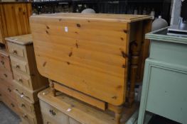 A pine drop-flap kitchen table.