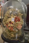 An unusual Victorian wool work sculpture of flowers under a glass dome (dome damaged).