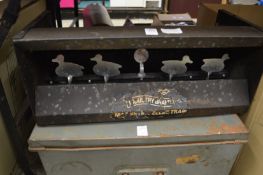 A metal shooting gallery target and an old tin trunk.