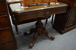 A 19th century oak fold-over card table on carved pedestal base.