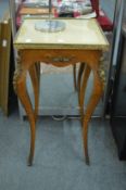 A French style ormolu mounted birds eye maple gueridon with glass covered clothed top.