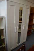 An Ikea Brimnes white painted three door wardrobe.