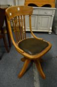 An Edwardian oak office swivel chair.