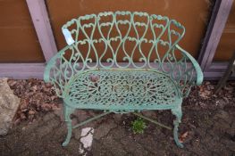 A green painted metal garden seat.