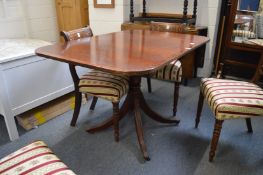 A reproduction mahogany drop-flap pedestal dining table.