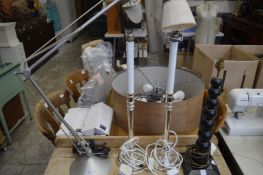 An angle-poise lamp, pair of table lamps and another lamp.