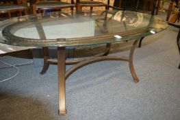 An oval glass topped metal framed coffee table.