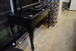 An ebonised music seat.