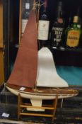 A small model sailing yacht.