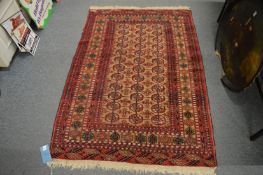 A small Persian bokhara rug (moth damage) 158cm x 110cm.