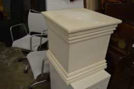 A white painted pedestal.