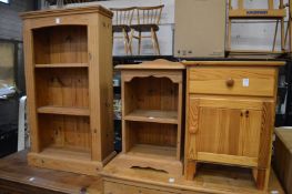 A pine bedside cupboard and two small bookshelves.