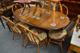 An Ercol drop-leaf pedestal dining table together with a set of six Ercol Prince of Wales splat-back