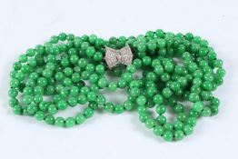 A GOLD FIVE ROW JADE NECKLACE with diamond clasp.
