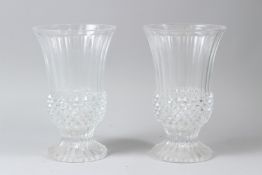 A PAIR OF MOULDED GLASS PEDESTAL VASES. 23cms high.