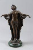 AN ART NOUVEAU STYLE BRONZE of a semi-nude female figure, her arms raised, mounted on a circular
