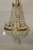 AN ORMOLU AND CUT GLASS CHANDELIER, with swags and prism drops. 50cms long x 30cms wide.