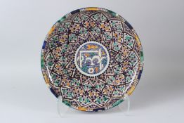 A LARGE ISLAMIC POTTERY DISH, enamel decorated with a calligraphy central panel. 34cms diameter.