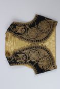 AN OTTOMAN TURKISH CHILD'S WAISTCOAT, black ground with gilt metal thread embroidery.