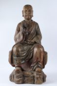 A LARGE CARVED WOOD FIGURE OF A BUDDHIST MONK, Ming Dynasty (1368 - 1644), modelled seated on a