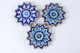A SET OF THREE 19TH CENTURY INDIAN MULTAN STAR SHAPED TILES. 16cms diameter.