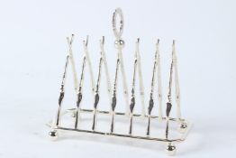 A PLATED TOAST RACK OF CROSSED RIFLES DESIGN. 19.5cms wide.