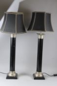 A PAIR OF CONTEMPORARY BLACK PAINTED COLUMN STYLE TABLE LAMPS AND SHADES, with plated mounts.