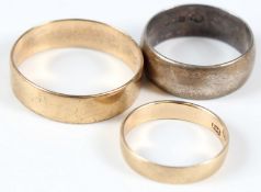 TWO 9CT YELLOW GOLD WEDDING BANDS; together with a silver band.