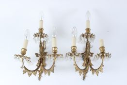 A PAIR OF ORMOLU THREE-LIGHT WALL APPLIQUES, with cut glass prism drops. 35cms long x 26cms wide.