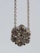 AN 18CT WHITE GOLD AND DIAMOND CLUSTER PENDANT AND CHAIN.