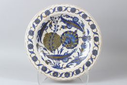 AN OTTOMAN TURKISH IZNIK POTTERY DISH, painted in blue and grey with stylised flowers. 36cms