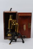 SWIFT & SON, LONDON, AN EARLY 20TH CENTURY BRASS MICROSCOPE, in a mahogany case with original bill