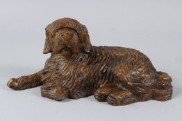 A CARVED WOOD MODEL OF A RECUMBENT DOG. 30cms long.