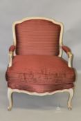 A FRENCH STYLE OPEN ARMCHAIR, with cream painted and parcel gilded carved wood frame, upholstered
