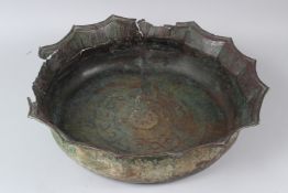 AN EARLY ISLAMIC COPPER BASIN, 12TH/13TH CENTURY, of shaped circular outline, having stylised
