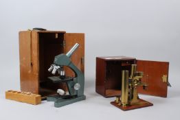 AN EARLY 20TH CENTURY BRASS MICROSCOPE, in a mahogany case; together with another microscope,