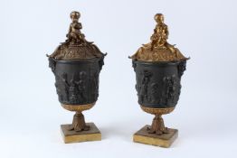 A GOOD PAIR OF BRONZE AND GILT BRONZE CLASSICAL STYLE URNS AND COVERS, the covers with cherub