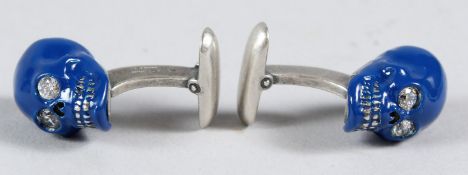 A PAIR OF SILVER AND ENAMEL SKULL CUFFLINKS.