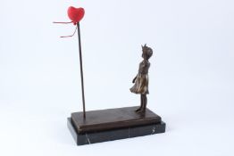 AFTER BANKSY. A bronze figure of a girl waving to a red heart shaped balloon, on a rectangular